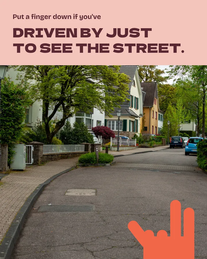 Put a finger down if you've driven by just to see the street. A quiet, tree-lined residential street with houses and parked cars. The red hand now has two fingers down.